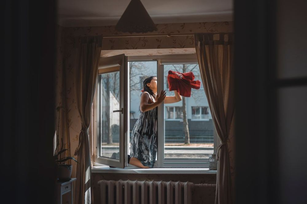 Cleaner wiping down a window with care
