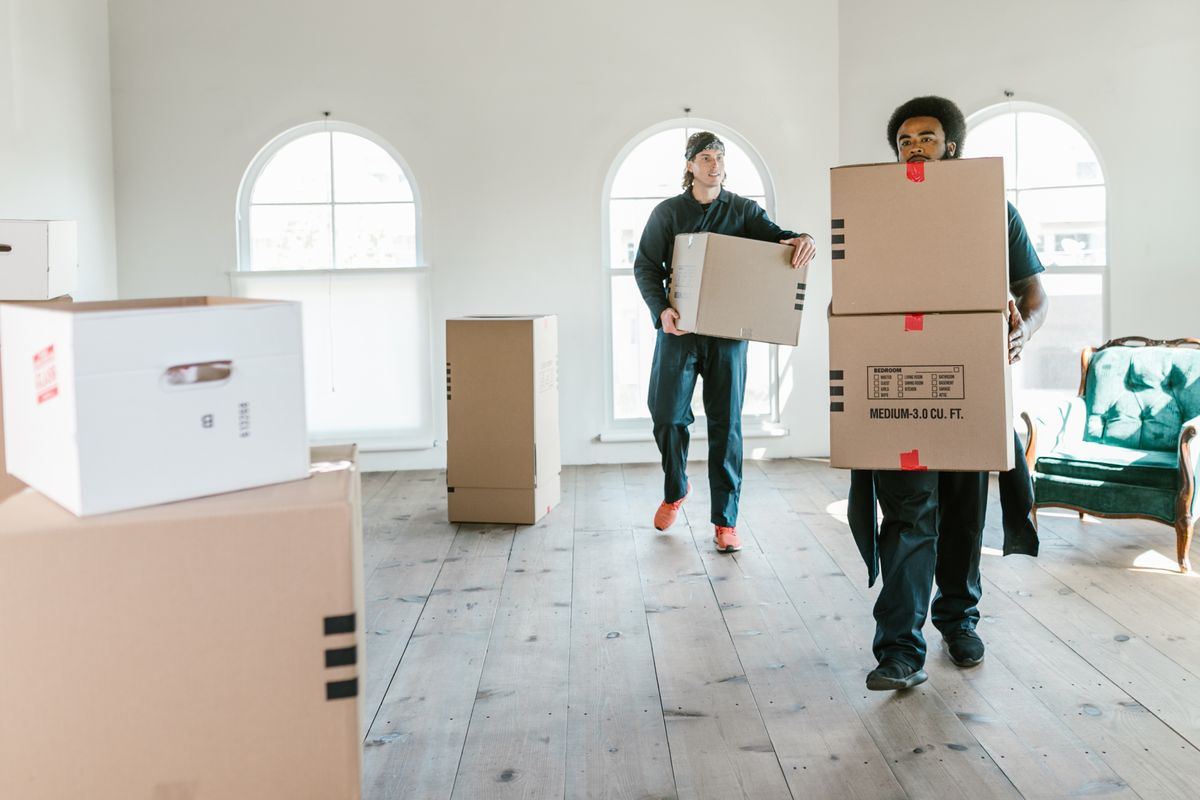Professional MMJ Resources movers carrying boxes into a home